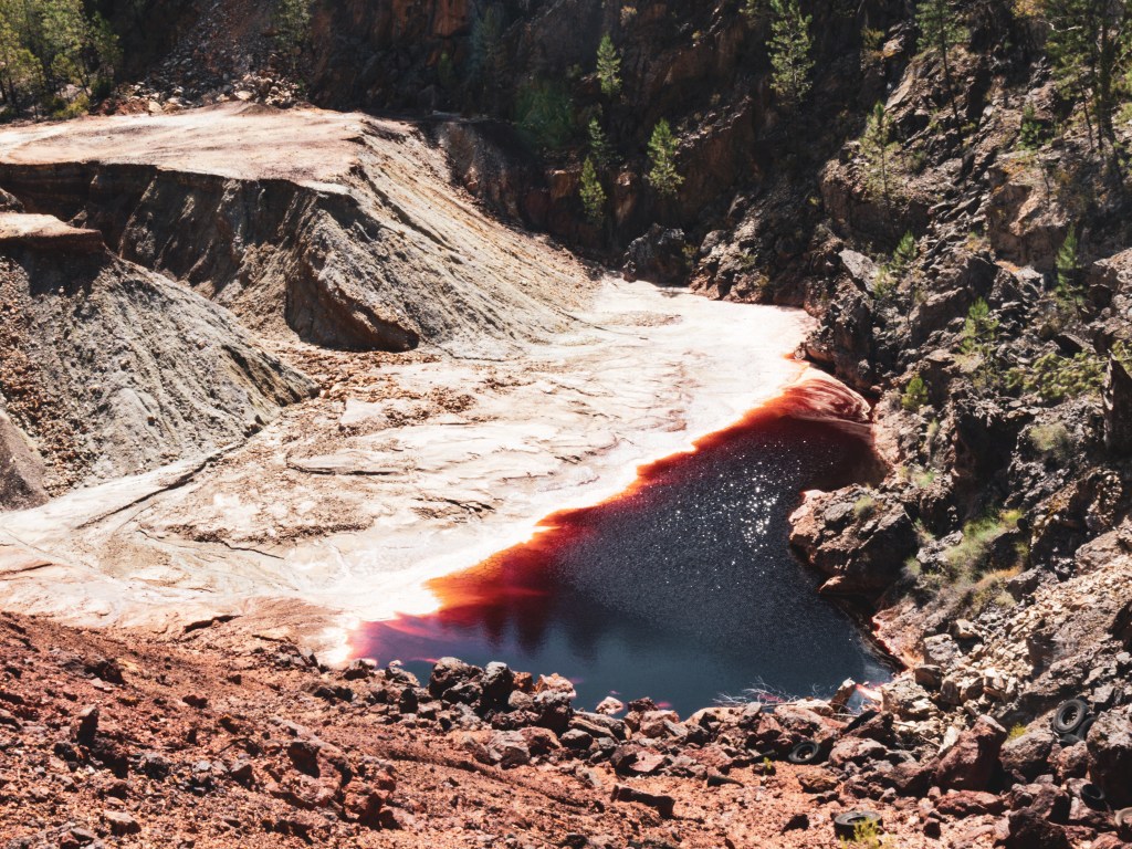 Red acid waters in the bottom of the open cast mine at San Miguel